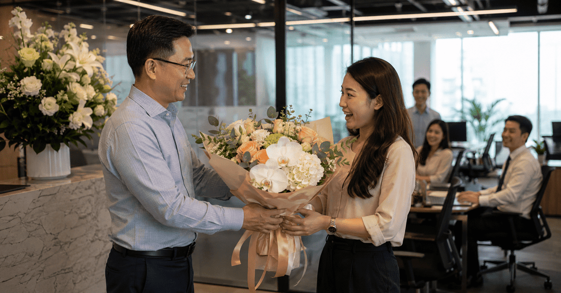 Corporate flower gifting in an office with a fresh bouquet being presented to an employee, highlighting floral memberships for professional and recurring business gifts.